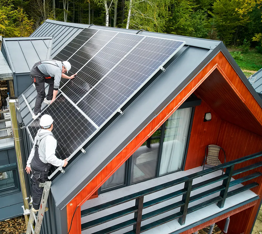 men workers installing solar panels on roof of hou